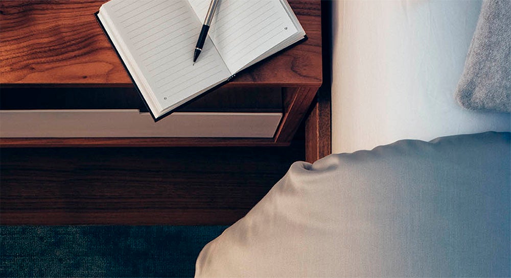 Note book and pen on bed side table